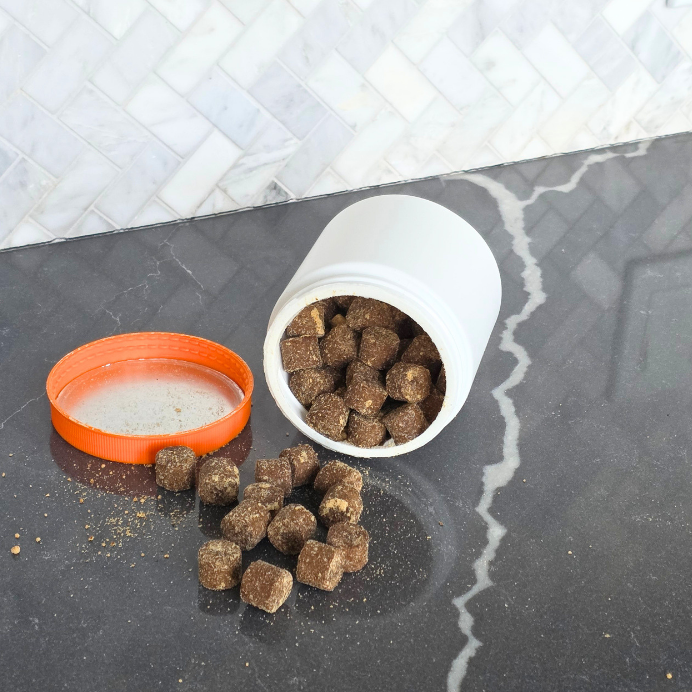Hand reaching into a shared jar of dog soft chews
